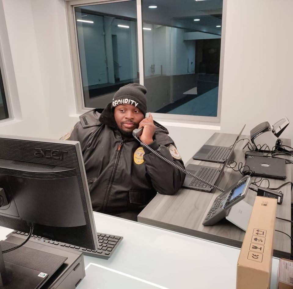Kamsnotch security officer answering calls at a building front desk