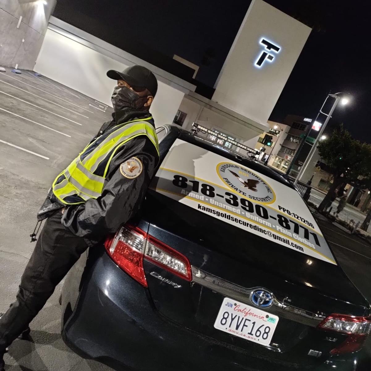 Kamsnotch officer in a high-visibility vest beside a marked patrol vehicle at night